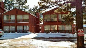 Un bâtiment à deux étages doté de grandes fenêtres et dont le sol est recouvert de neige.