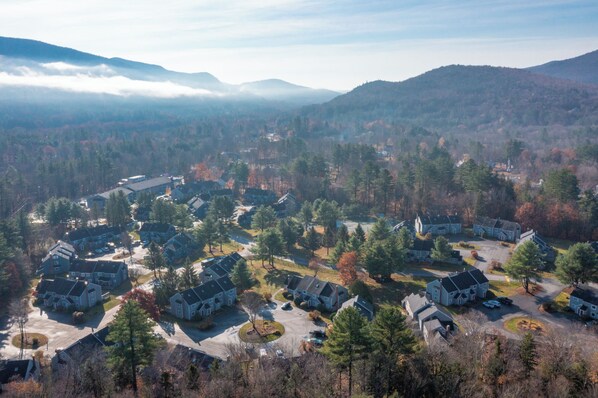 A residential area with houses, roads, and surrounding forested hills.