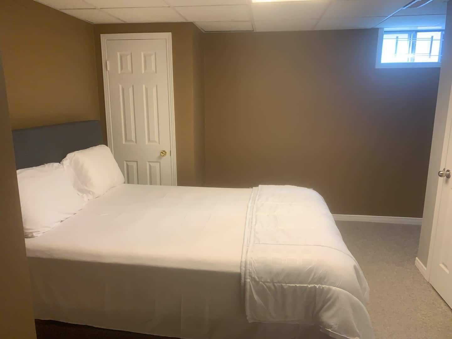 Una camera da letto con un letto, una porta e una finestra.