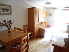 A cozy room with a wooden dining table, chairs, a sofa, and a cabinet. - 2-room apartment 4-6 pers, balcony, pool, center Arêches-Beaufort (Arêches-Beaufort)