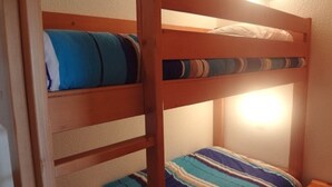 Ein Etagenbett mit gestreifter Bettwäsche und einem Nachttisch.