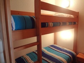 A bunk bed with striped bedding and a bedside table. - 2-room apartment 4-6 pers, balcony, pool, center Arêches-Beaufort (Arêches-Beaufort)