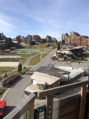A view of a ski resort with a ski lift, buildings, and a parking area. - Avoriaz: A magnificent apartment in the heart of the resort (Morzine)