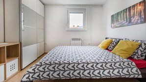 A bedroom with a bed, a window, a radiator, and a painting on the wall. - 3 bedroom cozy apartment in Koper (Koper)