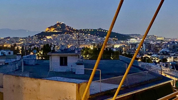 A cityscape with a hilltop building illuminated in the distance. - Charming Renovating Mets Apartment Athina (Athens)