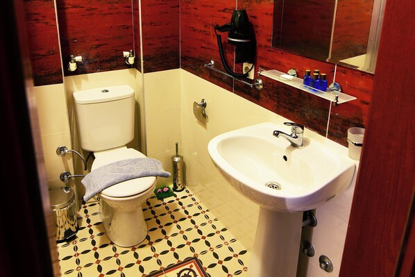 A bathroom with a toilet, sink, and a mirror. - Mylos Otel (Bozcaada)