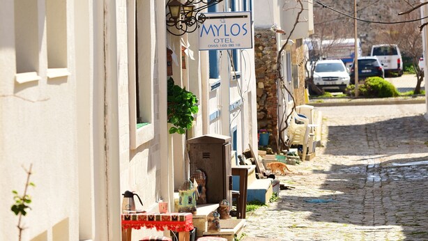 A narrow cobblestone street with a hotel named 'Mylos' on the left. - Mylos Otel (Bozcaada)