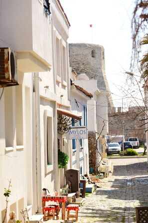 A narrow cobblestone street with a hotel named 'Mylos' on the left. - Mylos Otel (Bozcaada)