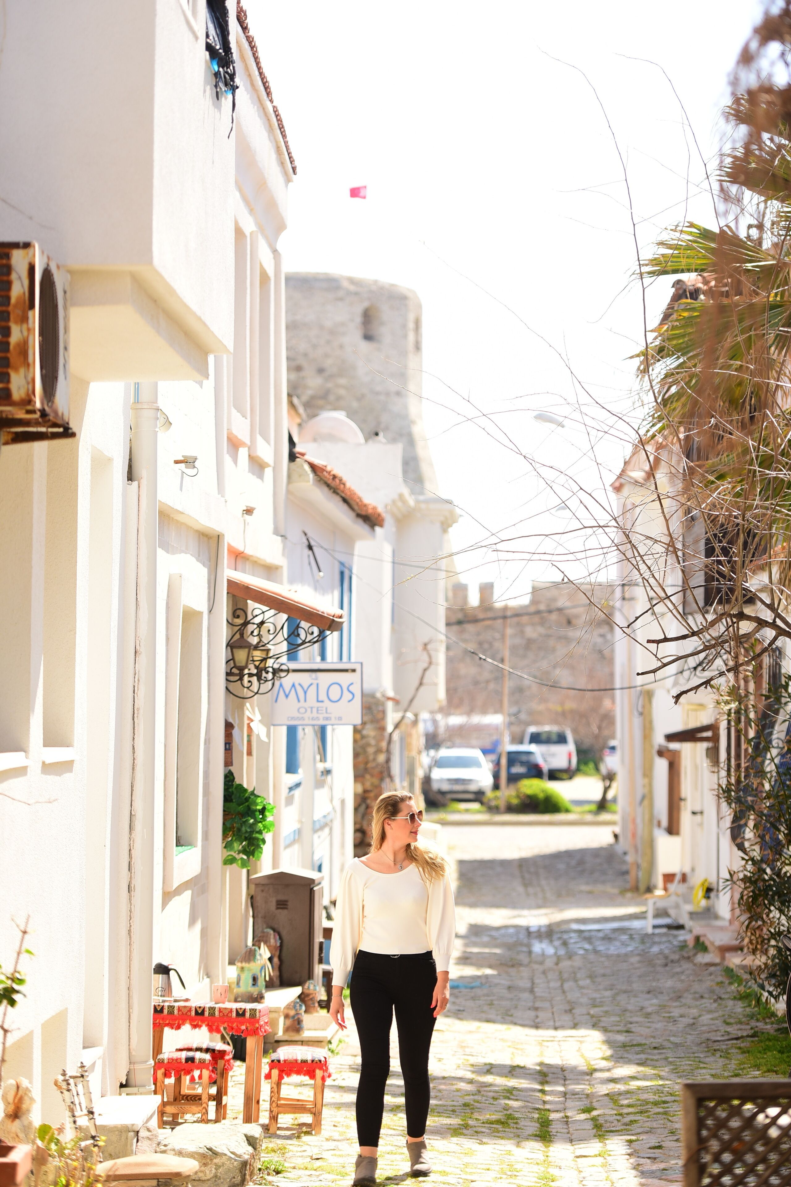 Une ruelle pavée étroite, avec un hôtel appelé « MYLOS » sur le côté gauche.