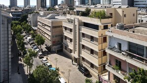 A cityscape with modern high-rise buildings, a central pedestrian area, and parked vehicles. - An amazing gem in the heart of TelAviv (Tel Aviv)