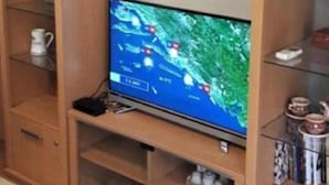 A wooden entertainment center with a television displaying a weather map. - Beautiful Apartment With Sea View, Trogir, Croatia (Trogir)