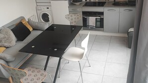 Um espaço compacto com cozinha compacta, área de refeições e sofá.