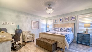 Ein Schlafzimmer mit einem Bett, einem Schreibtisch, einem Stuhl und einer Bank.