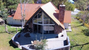 A house with a stone exterior, a sloped roof, and a large glass front.