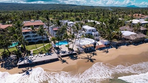 A resort with multiple buildings, a swimming pool, and a beach.