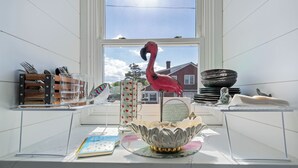 A kitchen counter with a decorative flamingo, a bowl, and various kitchen utensils. - ADORABLE STUDIO-OCEAN BLOCK REHOBOTH BEACH, 29 Maryland Ave, Unit 211 (Rehoboth Beach)