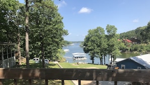 Une vue sur le lac depuis une terrasse agrémentée d’un belvédère, d’un quai et de bateaux.