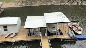 Un quai doté d’une zone de stockage pour bateaux abritée, d’une petite cabane et d’un espace de détente avec des bancs.