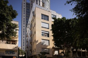 A multi-story building with a mix of architectural styles, including a modern glass tower and a beige facade with large windows.