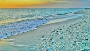Una playa con agua cristalina y una costa visible.