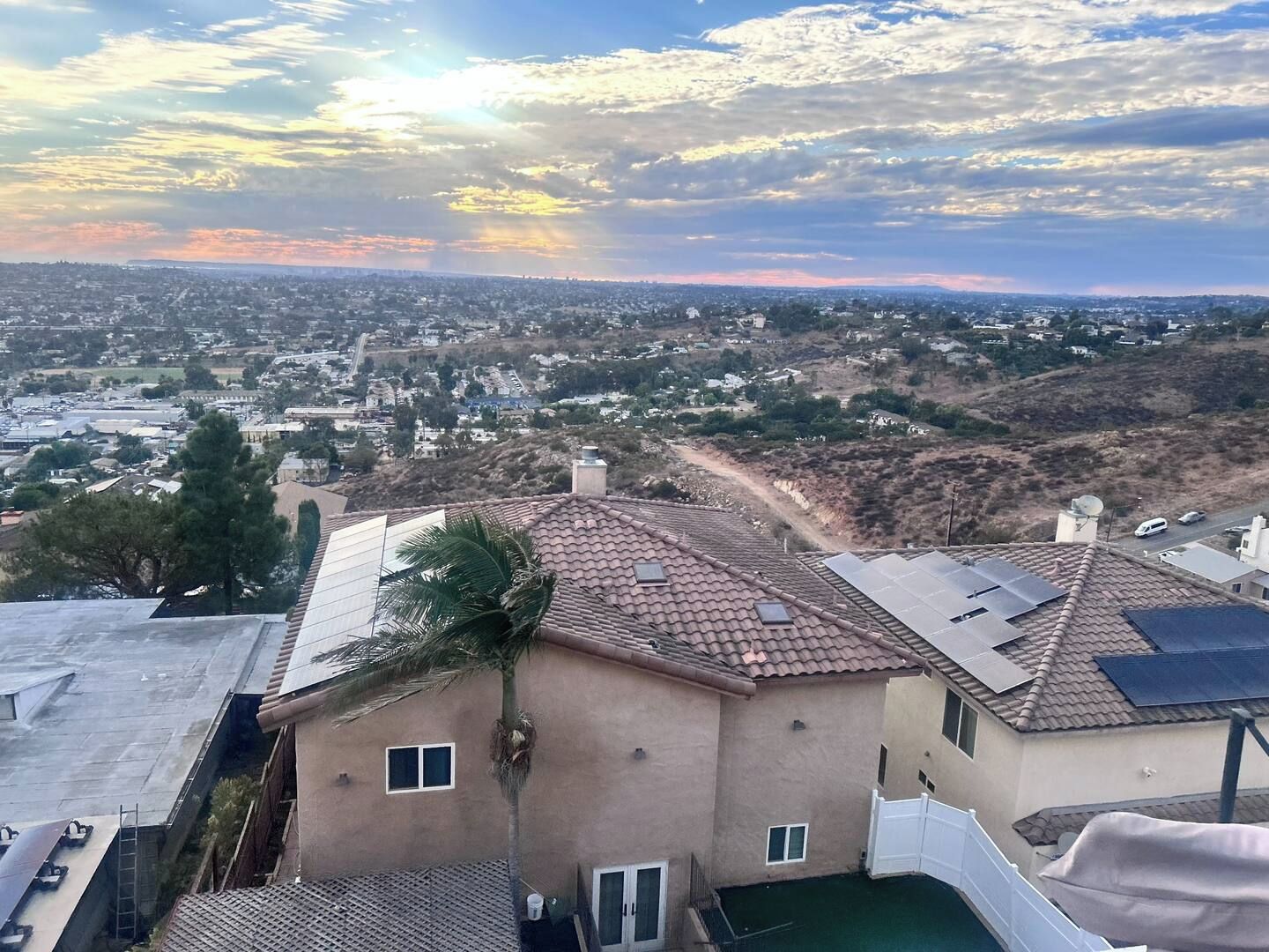 Zona residencial con casas, cielo despejado y atardecer.