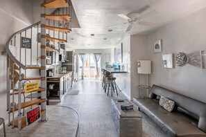 A modern interior with a staircase, kitchen, dining area, and a seating area with a sofa and ottoman. - Beautiful San Diego Views, Private Deck, Pool,  Sleeps 9 (Spring Valley)