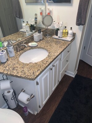 Bathroom features a granite countertop, white sink, and a mirror with a round frame.