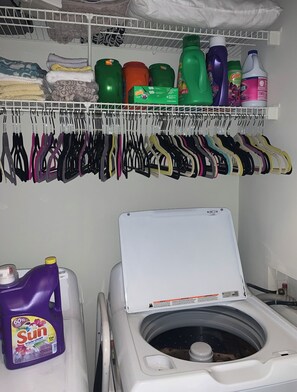 Convenient laundry facilities feature a front-loading washing machine and ample storage for cleaning supplies.