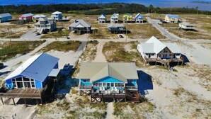 Una zona costera con varias casas de playa, algunas con muelles, y una vista despejada del océano.