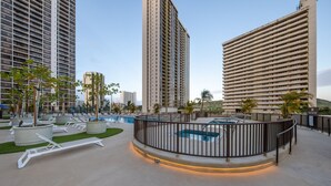 A rooftop pool area with a pool, lounge chairs, and a railing. - Luxurious, Free Parking & WiFi, Ocean View, Remodeled, 1 Bed Room, No Resort Fee (Honolulu)