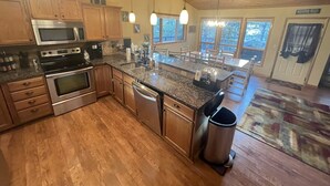 A spacious kitchen with wooden cabinets, stainless steel appliances, and a large island.