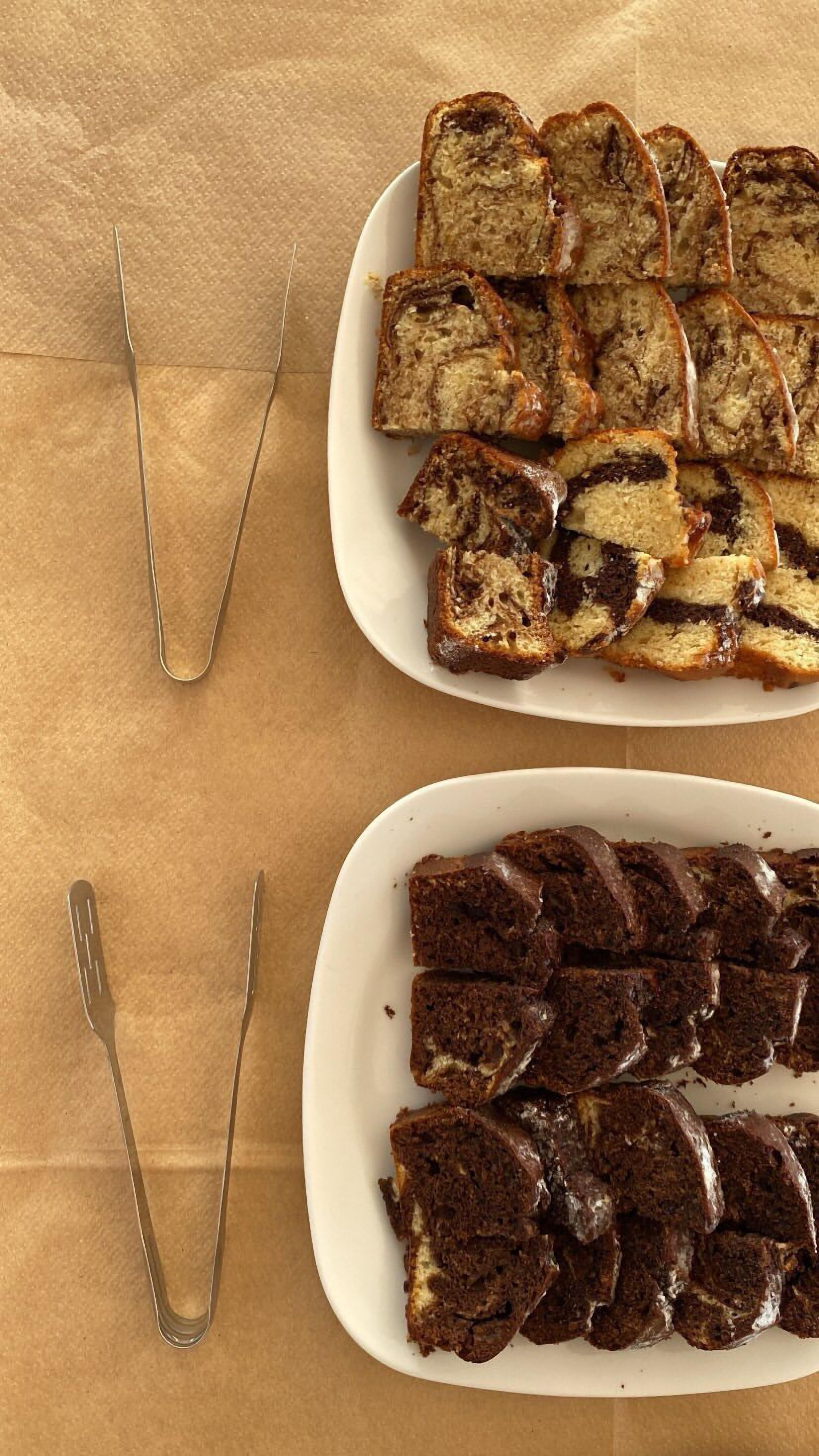 Two white plates with slices of bread, one with a lighter color and the other darker, on a brown surface.