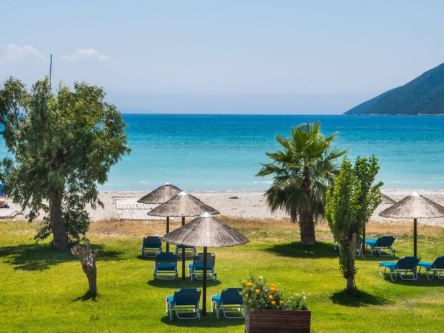 On the beach, black sand, sun loungers, beach umbrellas