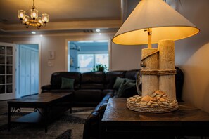 A living room with a wooden table lamp, a sofa, and a coffee table. - Buoy Bay– Luxury Waterfront Home in AC! (Atlantic City)