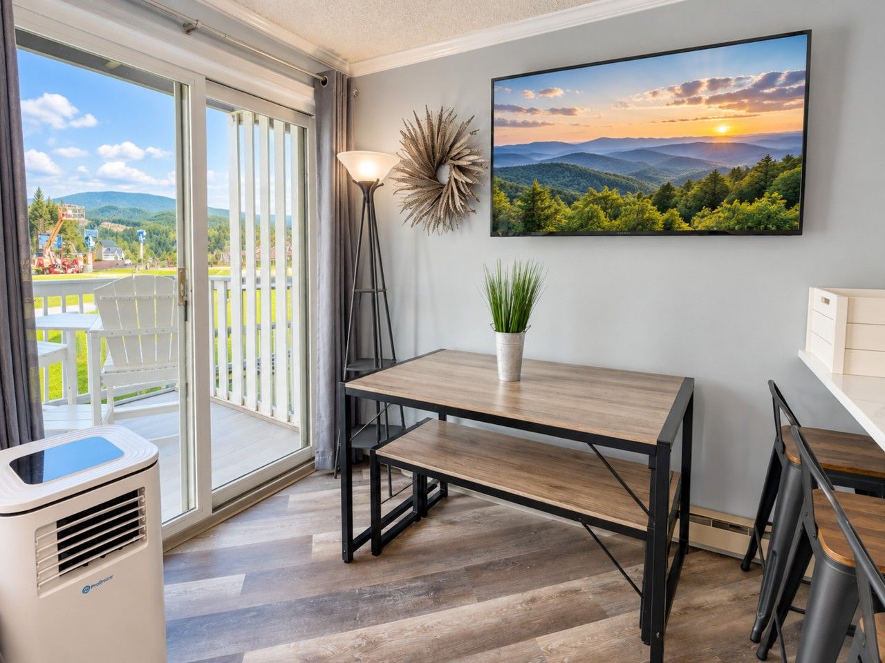 Eine moderne Küche mit einem Holztisch, einer Topfpflanze und einem großen Fenster mit Blick auf eine schöne Landschaft.