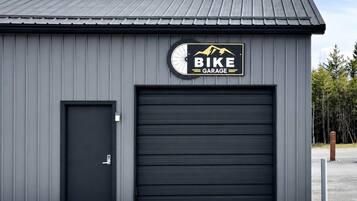 Edificio con puerta de garaje y otra puerta, con la etiqueta 'BIKE GARAGE'.