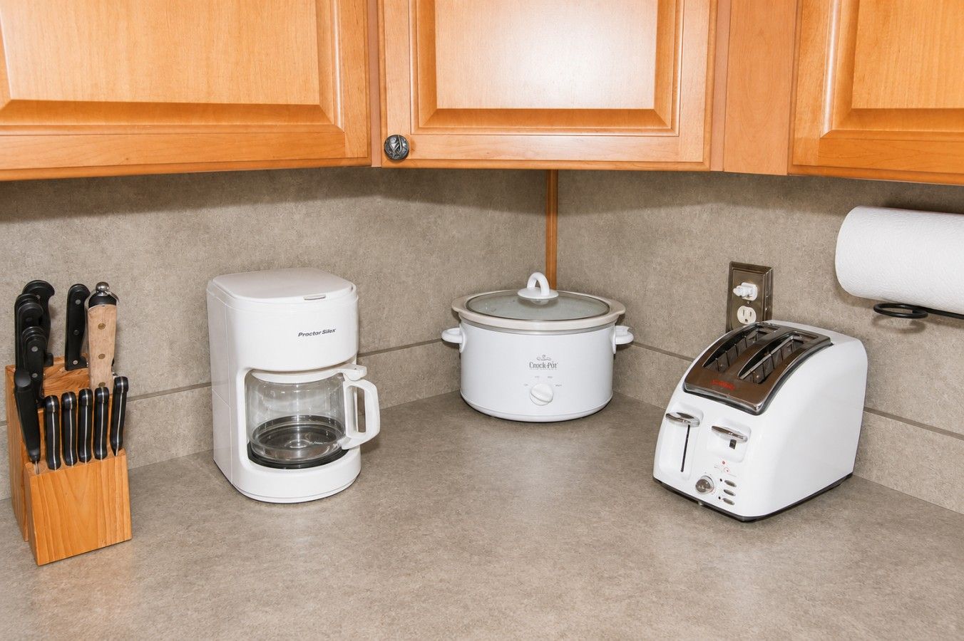 Una cocina equipada con cafetera, olla de cocción lenta y tostadora.