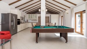 A spacious room with a pool table, a modern kitchen, and a red sofa. - Stunning home in Gostinjac (Gostinjac)