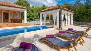 A pool area with lounge chairs and a covered seating area. - Stunning home in Gostinjac (Gostinjac)