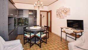 A compact living space with a dining area, a kitchenette, and a TV. - 2 bedroom lovely apartment in Chatillon (Chatillon)