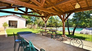 An outdoor patio with a wooden pergola, a table, and chairs. - Amazing home in Mejannes le Clap with swimming pool (Mejannes le Clap)