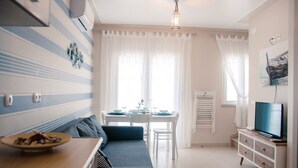 Una sala de estar moderna con sofá, mesa de comedor y televisor.