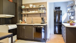 A compact kitchen with dark cabinets, a white countertop, a stainless steel refrigerator, and a coffee maker. - 2 bedroom cozy home in Tysse (Tysse)