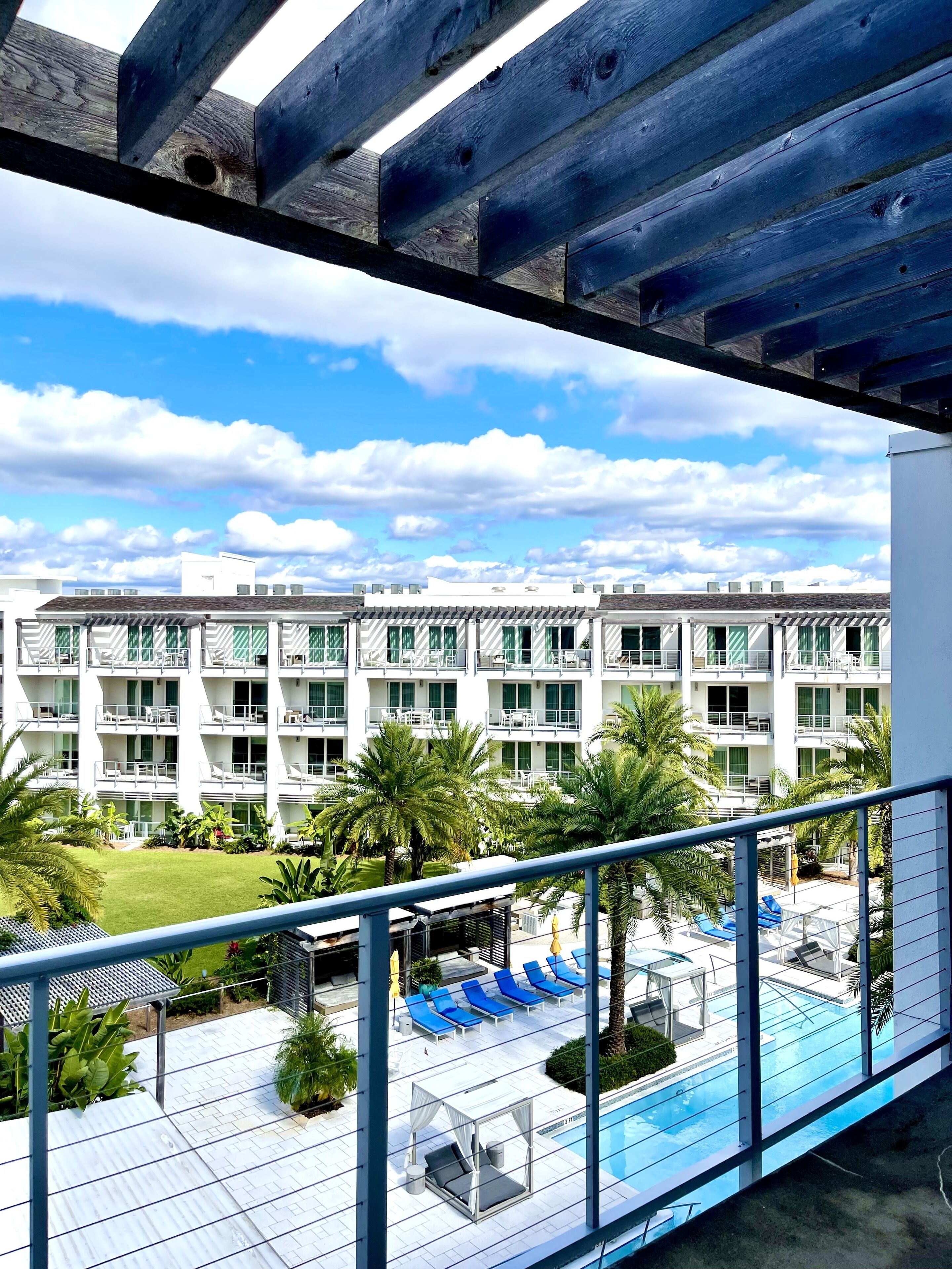 Un hotel amb zona de piscina, mobiliari exterior i vistes a l'exterior de l'edifici.