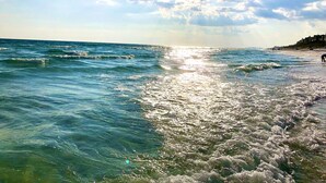 Une plage avec des vagues et un ciel dégagé.