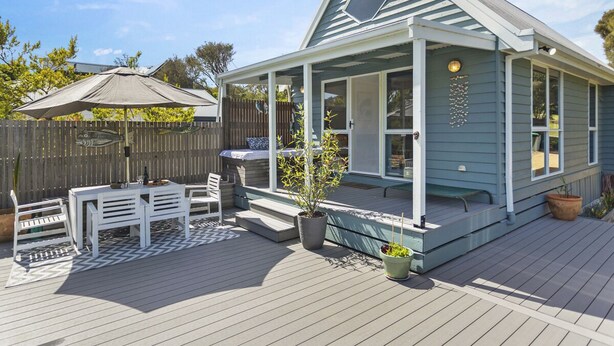 Ein überdachter Außenbereich mit Tisch und Stühlen, eine kleine Veranda mit Bank und eine Holzterrasse.