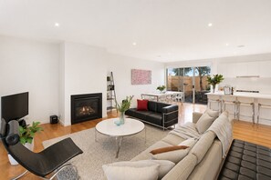A modern living room with a fireplace, a television, and a sofa.