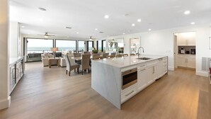 A spacious kitchen with a large island, modern appliances, and a view of the ocean. - True Beachfront!  2 Beachfront Masters - Best Location!! (Anna Maria Island)