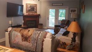A living room with a fireplace, a television, and a comfortable seating area. - Mountain Time in Pigeon Forge Close to Dollywood (Pigeon Forge)