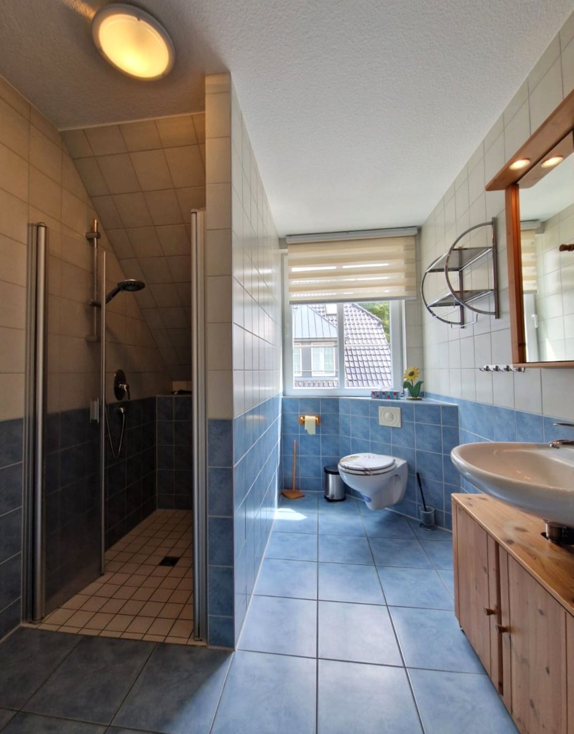 Et moderne badeværelse med bruser, toilet og håndvask.